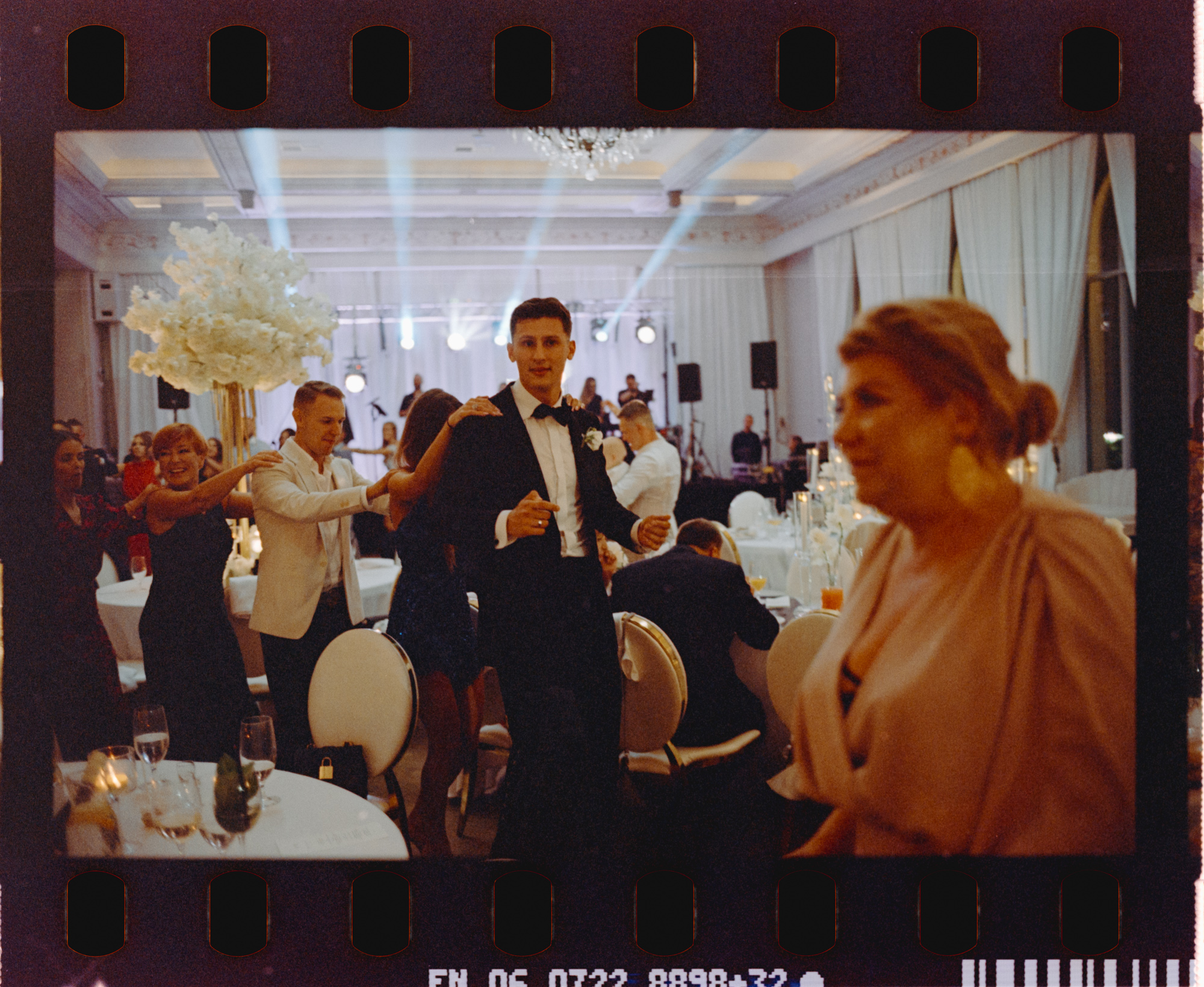 Pan młody i goście tańczą między stołami. Fotografia na filmie Kodak UltraMax.