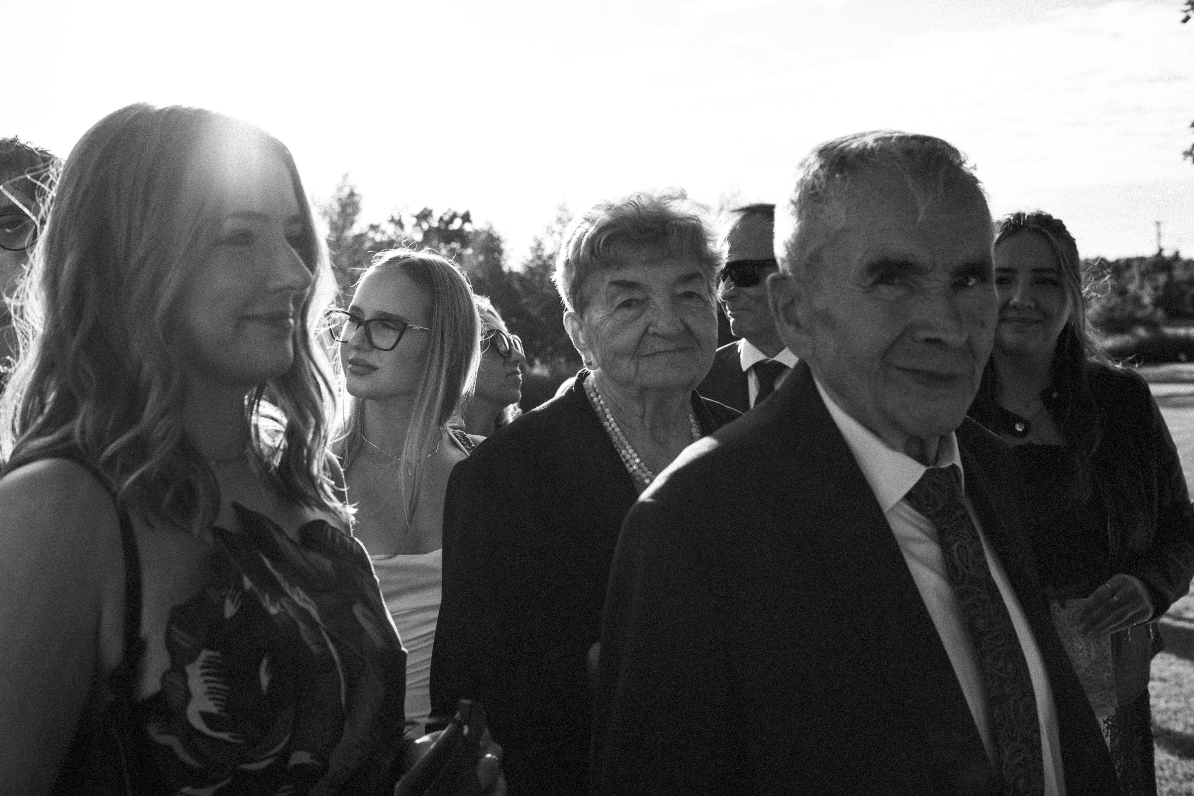 Bliscy podczas plenerowej ceremonii ślubnej. Czarno-biała fotografia.